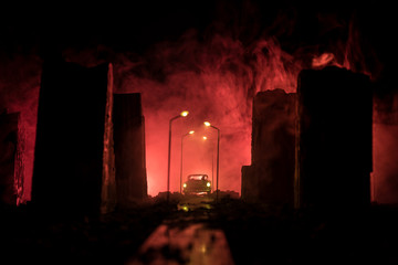 Fototapeta na wymiar Empty street of burnt up city, flames on the ground and blasts with smoke in the distance. Apocalyptic view of city downtown as disaster film poster concept. City destroyed by war.