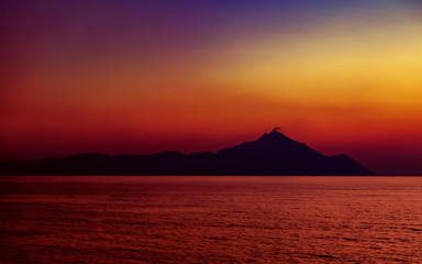Holy mountain Athos at sunset. View from the Platania beach, near Sarti, Sithonia, peninsula Halkidiki, Greece. Summer vacations.