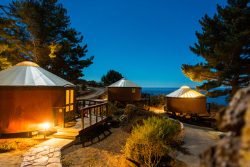 Yurts/tents under starlit sky in the woods, Big Sur, California - obrazy, fototapety, plakaty