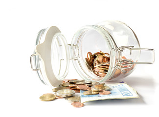 Banknote and coins in glass jar on white background