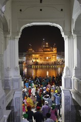 Amritsar, Punjab, India - October 4 2014: Holy worshipers in night time at the golden temple in Amritsar walking through an entrance