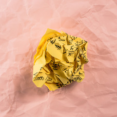 Crumpled multi colored paper balls with mathematical equations on multi colored plain paper, with...