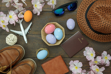 Table top view shot of decoration Happy Easter holiday background concept.Flat lay essential objects plan to travel vacation on modern brown wooden at office desk. Accessory for traveler to trip.