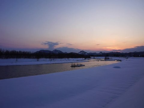 冬の夕暮れ　川　日没　雪景色　太陽