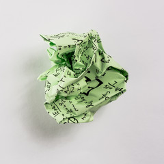 Crumpled multi colored paper balls with mathematical equations on multi colored plain paper, with...
