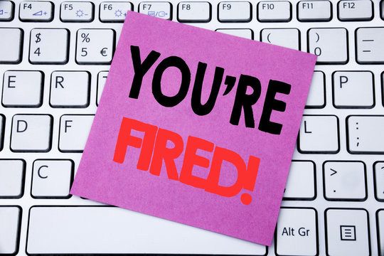 Handwriting Announcement text showing You Are Fired. Business concept for Unemployed or Discharge written on sticky note paper on the white keyboard background.