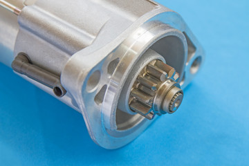 Starter motor of silver on a blue background