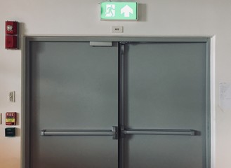 Building Emergency Exit with Exit Sign and Fire Extinguisher.