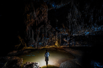 Woman standing in cave full of New Zealand glow worms