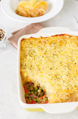 Shepherds pie -  Irish traditional food. Served in a ceramic dish on a white stone background.