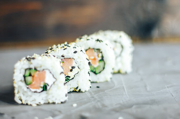 Japanese sushi roll philadelphia on black stone. Selective focus. Blurred foreground and background. Concrete grey background