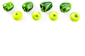 Green vegetables pattern. Shiny bell pepper and fresh apple on white background top view copy space