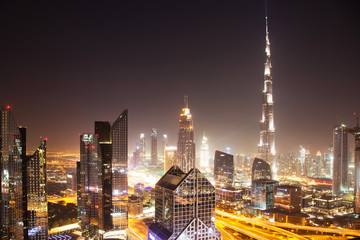 Fototapeta premium DUBAI, UAE - FEBRUARY 2018: Dubai skyline at sunset with Burj Khalifa, the world tallest building and Sheikh Zayed road traffic
