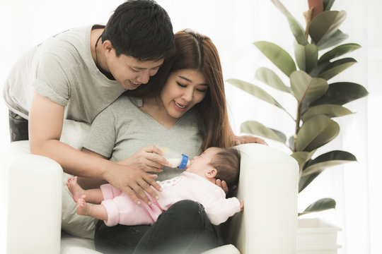 Asian Mother And Father At Home With Baby.