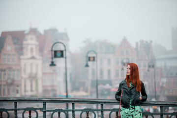 young redhead girl stading near bridge