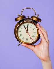 Female hand holding vintage alarm clock
