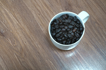 Coffee Bean in Cup on the Wooden floor  