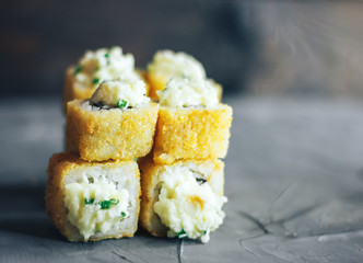 Japanese sushi roll, hot and fried, tempura maki on concrete grey background