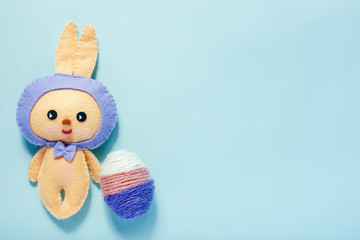 Easter rabbittoy with three color egg is on blue background.