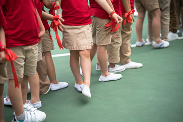 Uniformed children aligned legs standing on school playground