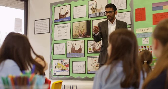 4K Happy elementary school teacher talking to his class & asking questions. Slow motion