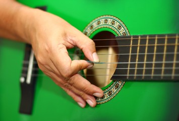 Hand playing guitar in close up