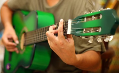 Hand playing guitar in close up