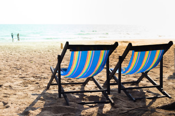 Two beach chair on the beach at sunset.