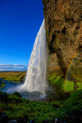 Seljalandsfoss falls, Iceland from a side view with a rainbow late in the day