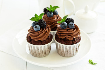 Chocolate cupcakes, with chocolate cream and fresh berries.