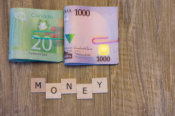 Nigerian Naira and Canadian Dollars with Money spelled out in letter tiles