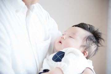 赤ちゃんを抱っこするパパ