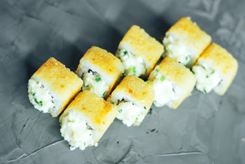 Japanese sushi roll, hot and fried, tempura maki on concrete grey background