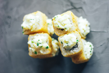Japanese sushi roll, hot and fried, tempura maki on concrete grey background