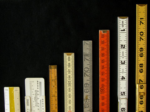 Rulers and scales in metric and inches ascend along a chart or graph representing measurement, metrics, precision, increase, growth, accuracy and results with copy space.
