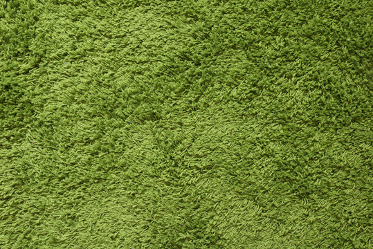 Green carpet. Surface imitating green grass. A close-up photograph. Top view 