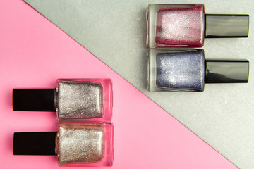 Nail Polish manicure on pink and gray geometric background. Color trend, glamorous manicure