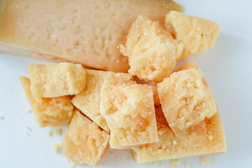 pile of pieces of parmesan cheese on a white background