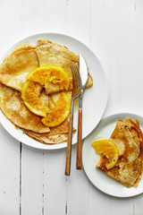 Overhead image of pancakes with orange confiture in white plate on wooden table