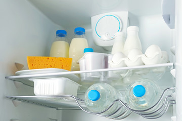 Many different dairy products in modern refrigerator