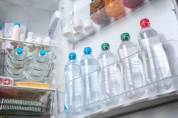 Bottles of cool water on refrigerator door shelf