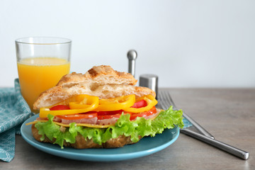 Plate with delicious croissant sandwich on table