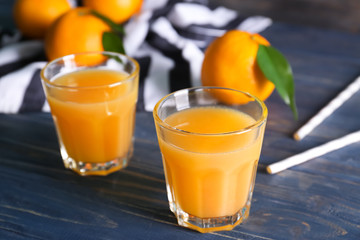 Glasses with fresh orange juice on wooden table