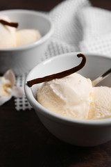Fototapeta na wymiar Bowl with delicious vanilla ice cream on table