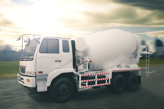 White concrete mixer truck with dramatic sky