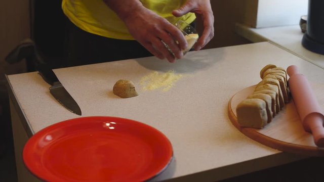 Man takes a piece of dough and rolls it out with a rolling-pin to the state of a thin bread. Cooking lenten bread at home for dietary nutrition. Time lapse.