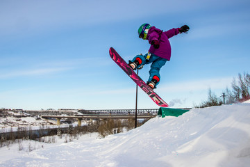 Kid jumping on a snowboard