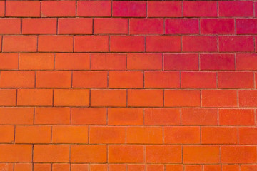 Brick wall, floor and large blocks of brick with a color gradient from red to orange.