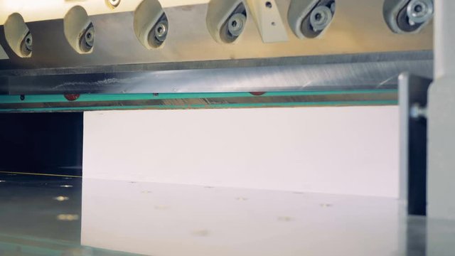 Industrial guillotine machine at printing factory. Industrial cutter for cutting paper shears.
