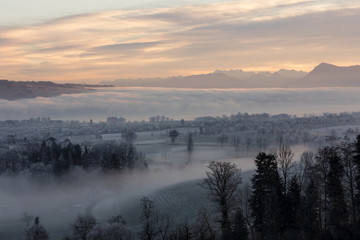 Obraz premium Ice cold winter morning with fog and Mount Rigi in the background during the dawn in Central Switzerland